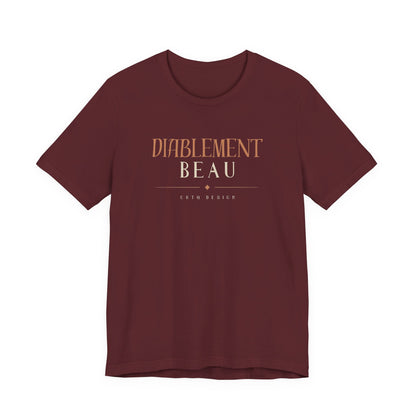 A short-sleeve crewneck t-shirt in maroon with a graphic print on the chest reading 'DIABLEMENT BEAU' and 'Chtq DESIGN' in a warm tan color, displayed against a solid white background.