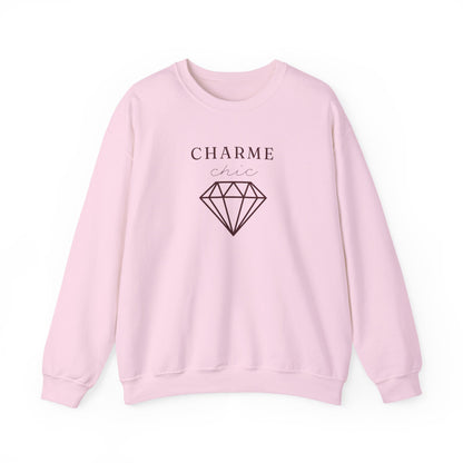 A light pink crewneck sweatshirt featuring a black graphic print on the front with the text 'CHARME chic' and a diamond illustration, displayed on a clean white background.