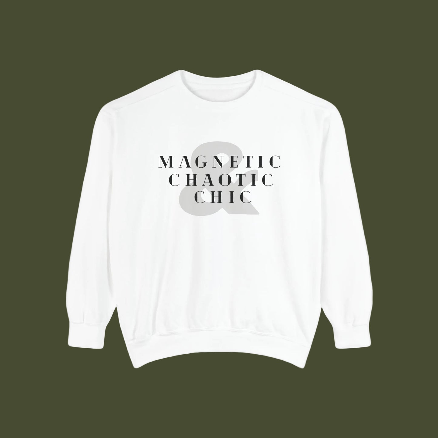 A white crewneck sweatshirt with a graphic print on the chest reading 'MAGNETIC CHAOTIC CHIC' in black serif text over a large gray ampersand symbol.