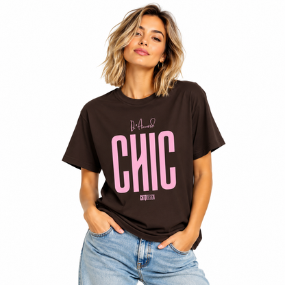 Young woman wearing a dark chocolate brown D’Accord CHIC graphic T-shirt with light pink lettering and blue jeans.