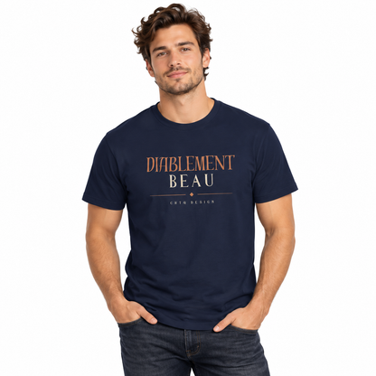 A man wearing a maroon crewneck t-shirt with 'DIABLEMENT BEAU' and 'CHTQ DESIGNS' printed on the chest, paired with light beige pants, against a plain white background.