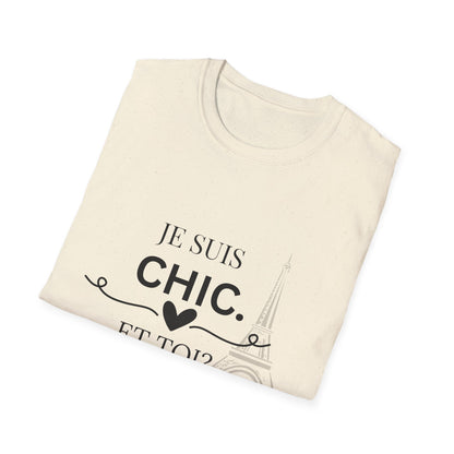 Folded cream “Je Suis Chic. Et Toi?” graphic T-shirt with black text and an Eiffel Tower illustration, paired with light blue jeans against a light gray studio background.