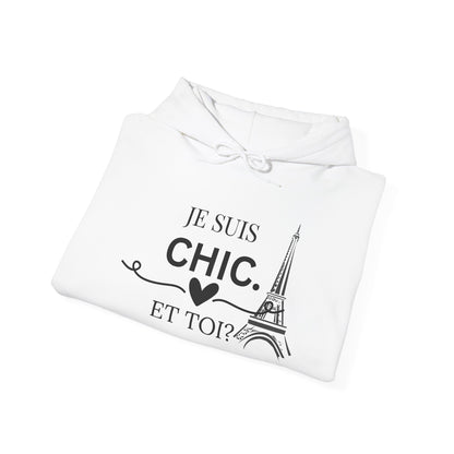 A folded white hoodie with a black graphic print that reads 'JE SUIS CHIC. ET TOI?' with a heart and an illustration of the Eiffel Tower, shown on a plain white background.