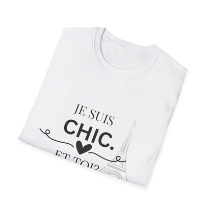 Folded white “Je Suis Chic. Et Toi?” graphic T-shirt with black text and an Eiffel Tower illustration, paired with light blue jeans against a light gray studio background.