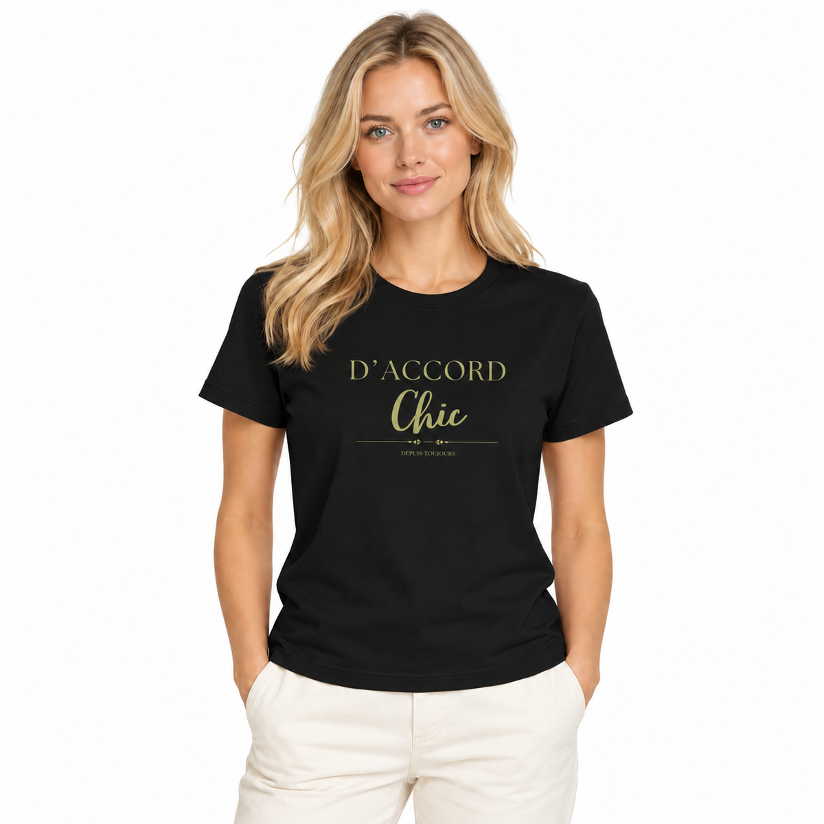 A woman modeling a black short-sleeve crewneck t-shirt with gold printed text reading 'D'ACCORD Chic' and 'depuis toujours' on the chest, paired with off-white pants against a plain white background.