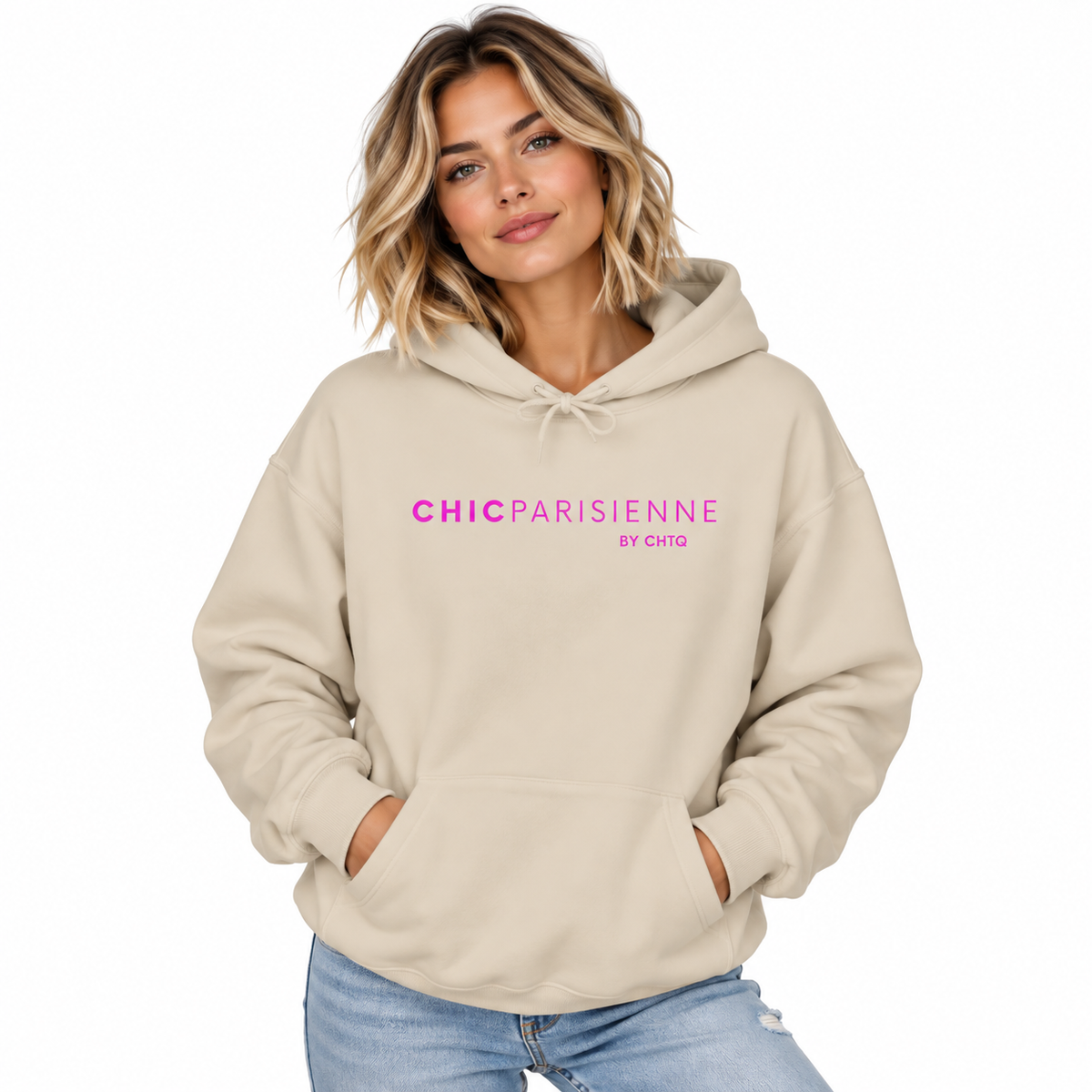 A woman wearing a beige hoodie with pink text reading 'CHICPARISIENNE by chtq' on the chest, paired with light blue jeans, against a plain white background.
