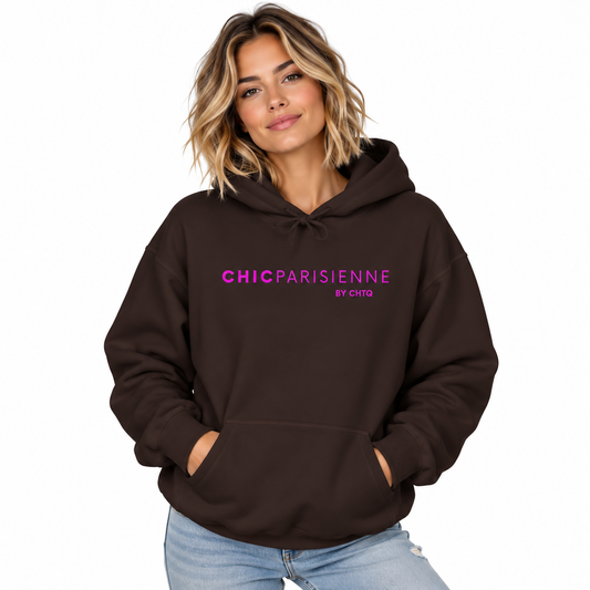 A woman wearing a dark brown pullover hoodie with 'CHICPARISIENNE BY CHIC' printed in pink across the chest, paired with light blue jeans, set against a plain white background.