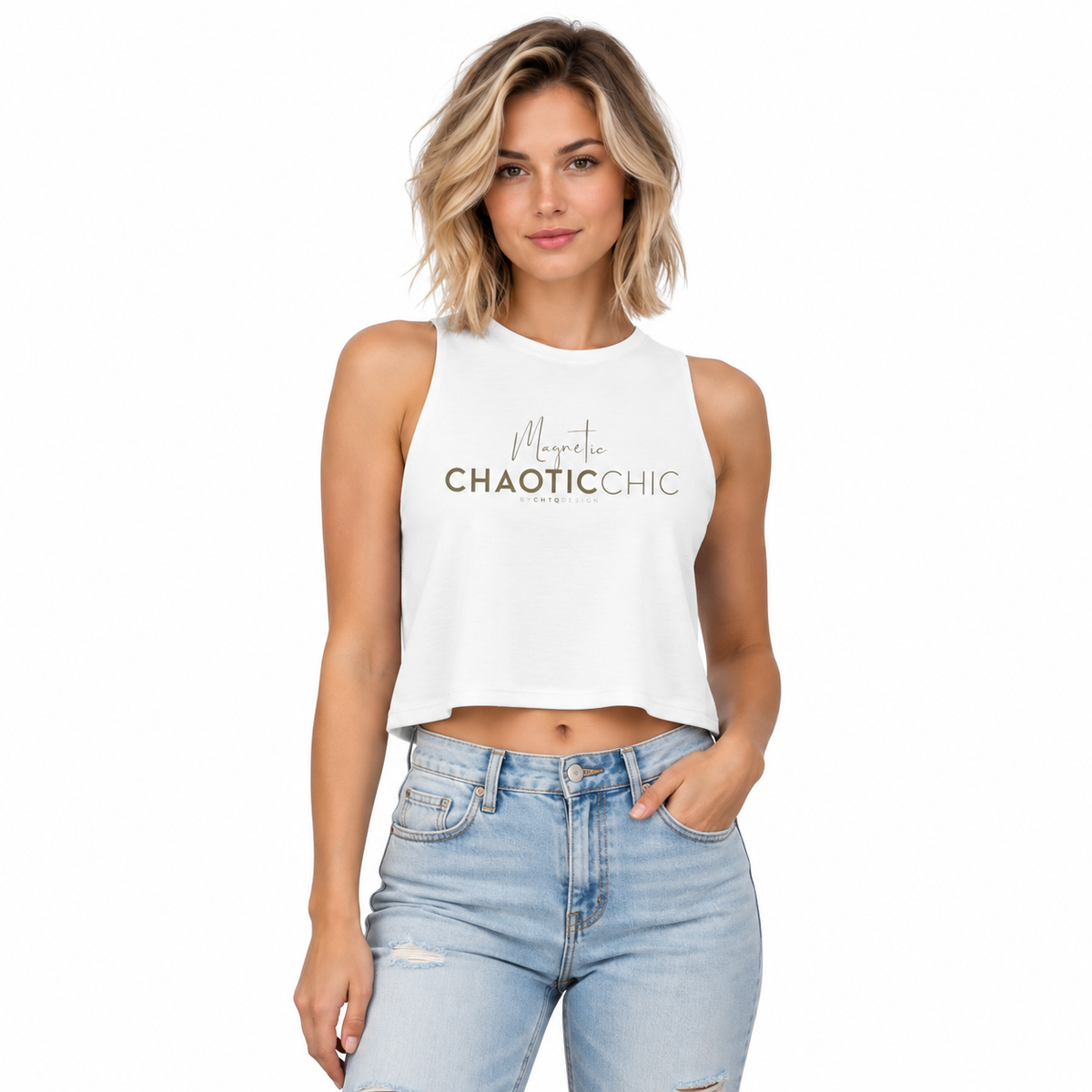 A woman modeling a white sleeveless crop top with 'Magnetic Chaotic Chic' printed on the front, paired with light-wash distressed jeans, against a plain white background.