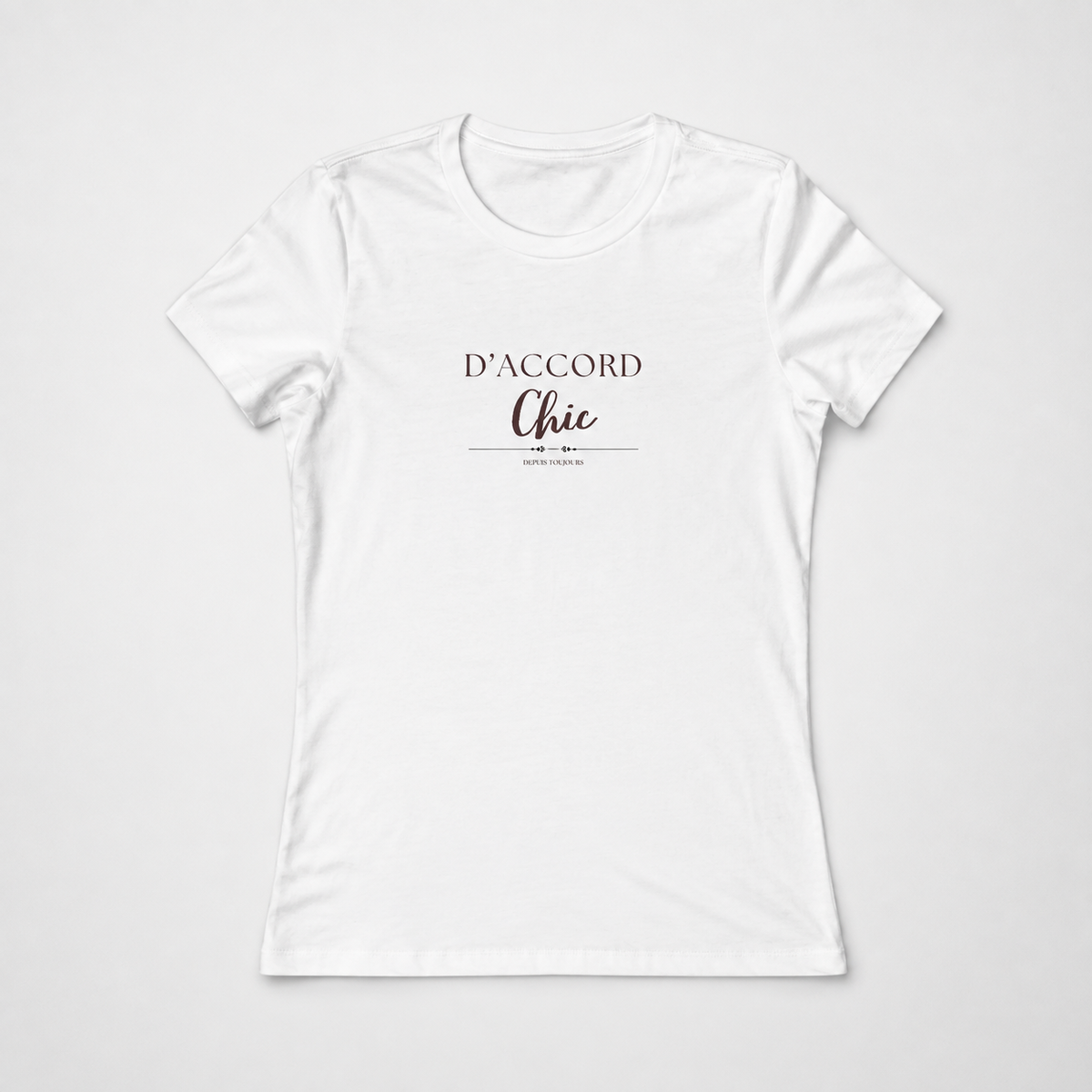 White short-sleeve crewneck T-shirt featuring the “D’Accord Chic” graphic in black and brown lettering on the front, displayed against a light gray background.