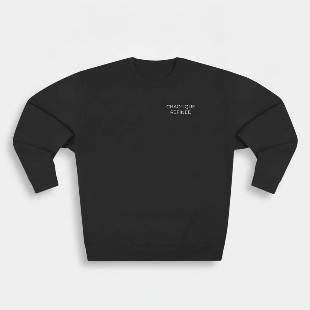 A black crewneck sweatshirt with the words 'CHAOTIQUE REFINED' printed in small white text on the left chest, displayed on a light gray background.