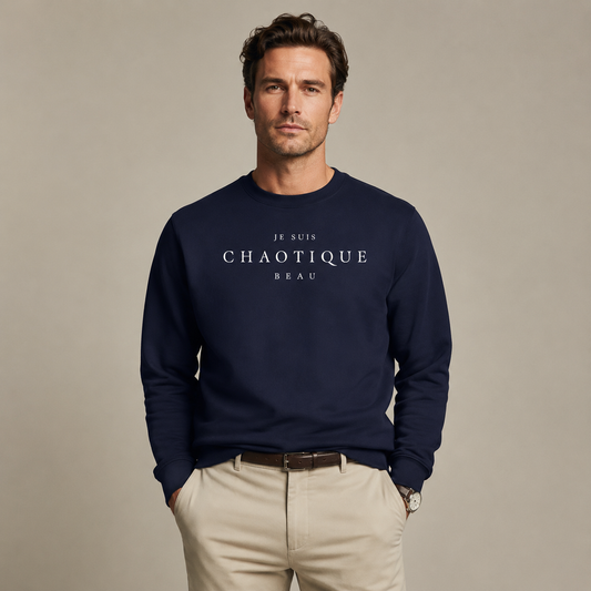 Man wearing a navy Je Suis Chaotique Beau sweatshirt with beige trousers in a minimalist editorial studio setting