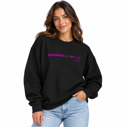 A woman wearing a black crewneck sweatshirt with 'DESIGNEDOUTOFLINE BYCHTQ' printed in pink across the chest, paired with light blue jeans, against a plain white background.