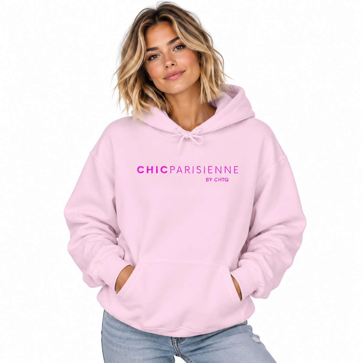 A woman wearing a light pink pullover hoodie with 'CHICPARISIENNE by chic' printed in pink across the chest, paired with light blue jeans against a solid white background.
