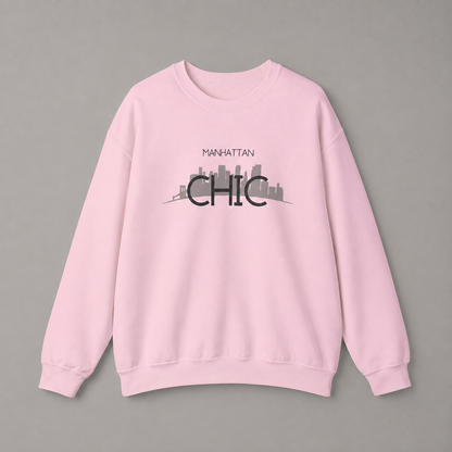 Light pink MANHATTAN CHIC crewneck sweatshirt featuring black typography and a muted olive New York skyline graphic, 
 against a neutral gray studio background.